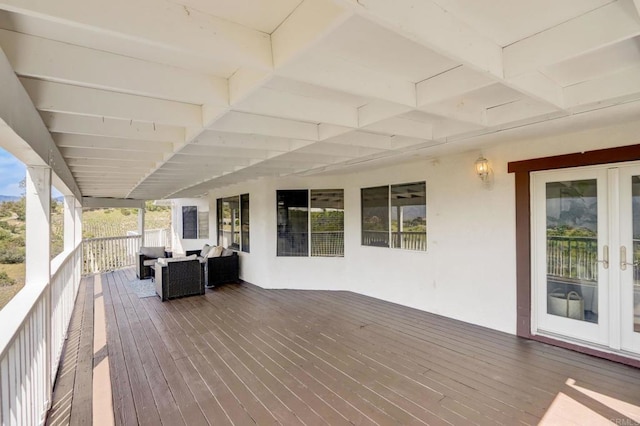 wooden terrace with an outdoor living space