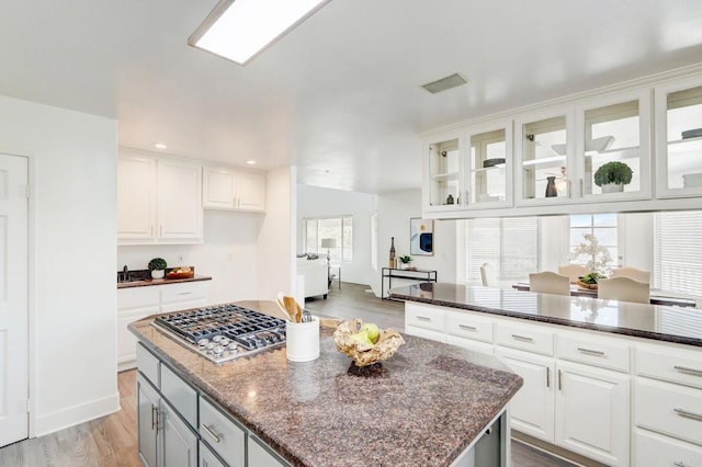 kitchen featuring white cabinets, dark stone countertops, and a center island