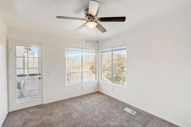 spare room with ceiling fan and light colored carpet