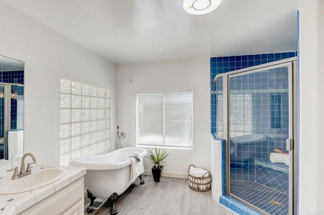 bathroom with vanity, hardwood / wood-style flooring, and shower with separate bathtub