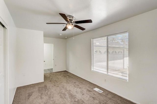 carpeted empty room featuring ceiling fan