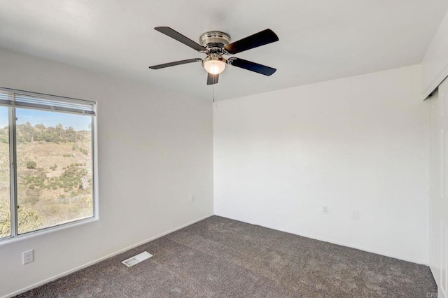 spare room featuring carpet floors and ceiling fan