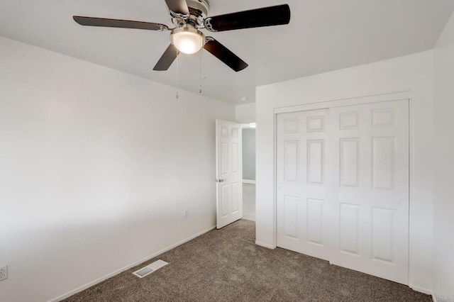 unfurnished bedroom featuring ceiling fan, a closet, and carpet flooring