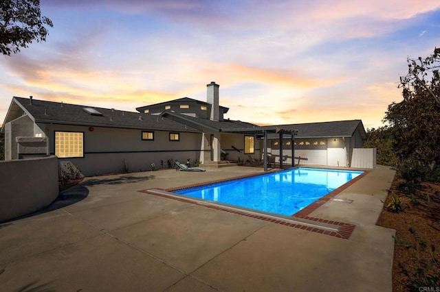 pool at dusk featuring a patio