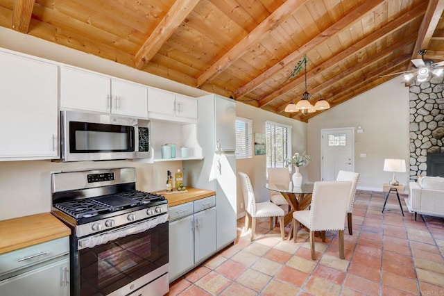 kitchen featuring wooden ceiling, appliances with stainless steel finishes, white cabinets, and decorative light fixtures