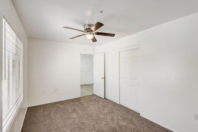 unfurnished bedroom featuring ceiling fan, a closet, and carpet flooring