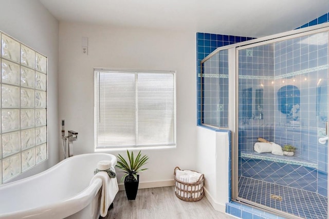 bathroom featuring plus walk in shower and hardwood / wood-style flooring