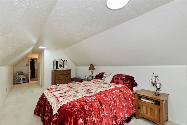 carpeted bedroom with a textured ceiling and lofted ceiling