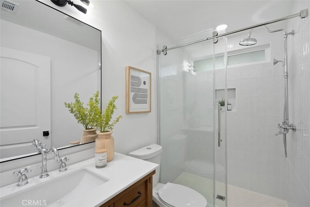 bathroom with an enclosed shower, vanity, and toilet