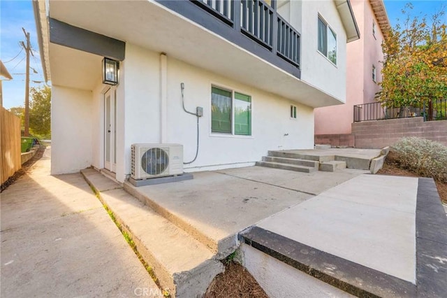 back of property with ac unit and a patio