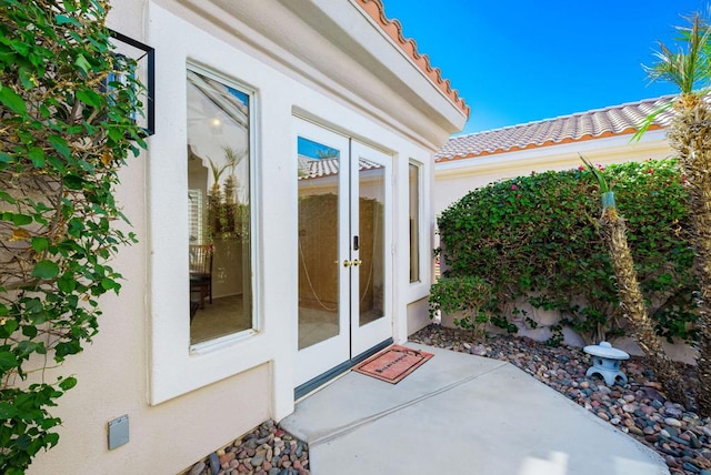 property entrance featuring a patio area and french doors