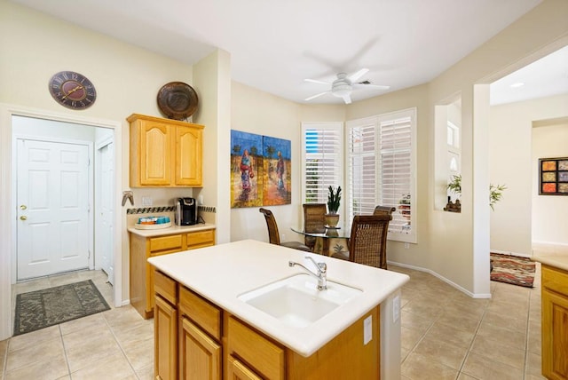 kitchen featuring a kitchen island with sink, sink, ceiling fan, and light tile patterned floors