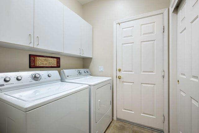 laundry room featuring cabinets, light tile patterned flooring, and washer and dryer