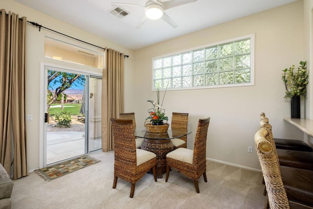 carpeted dining area with ceiling fan