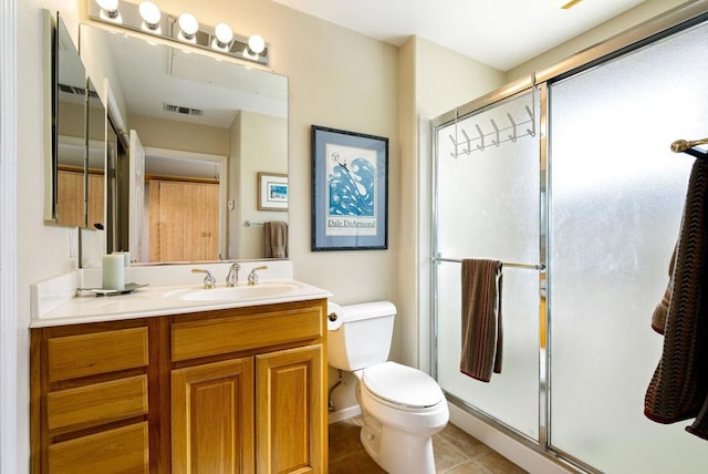 bathroom featuring tile patterned flooring, vanity, toilet, and a shower with shower door