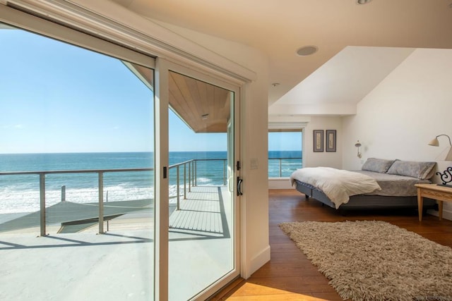 bedroom featuring a water view, multiple windows, access to exterior, and dark hardwood / wood-style flooring