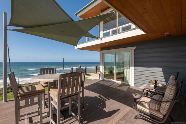 wooden deck featuring a water view and a view of the beach