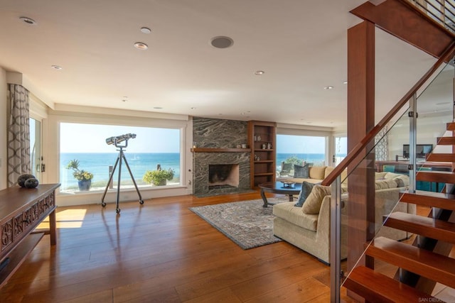 living room with a fireplace, wood-type flooring, and a water view