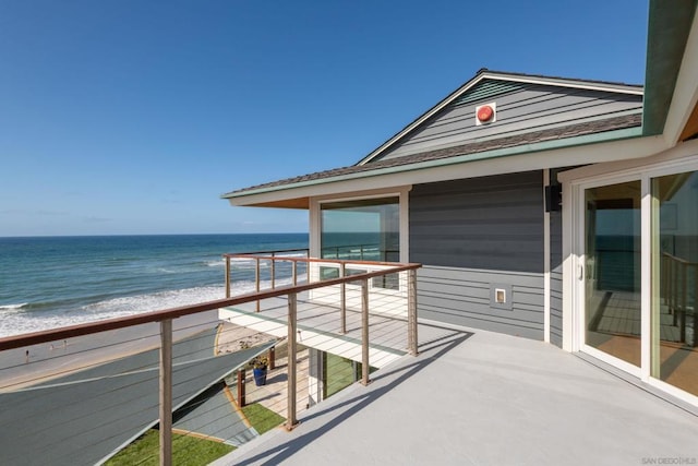 balcony featuring a view of the beach and a water view