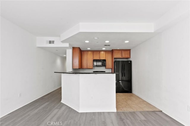 kitchen featuring black appliances and light wood-type flooring