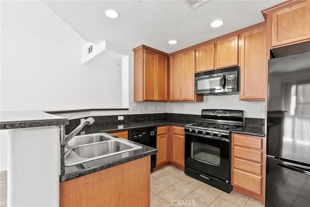 kitchen with black appliances, dark stone countertops, light tile patterned floors, and kitchen peninsula