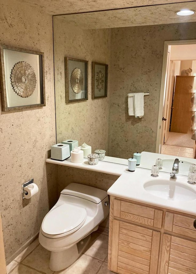 bathroom featuring toilet, tile patterned flooring, and vanity