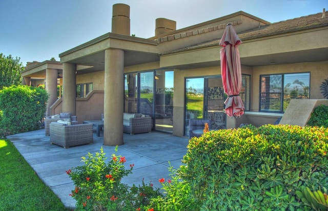 back of house with an outdoor living space and a patio