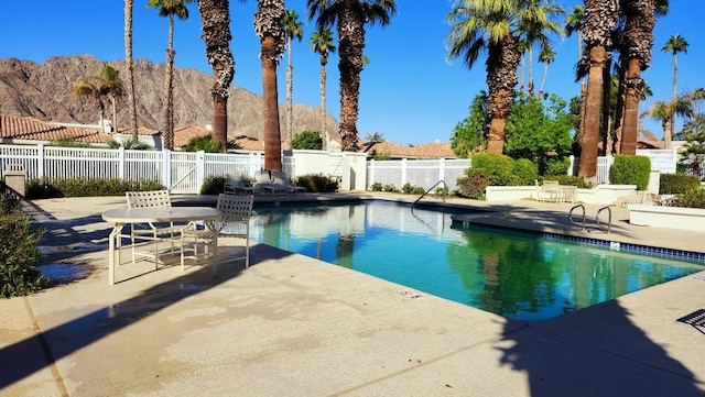 view of swimming pool featuring a patio area and a mountain view