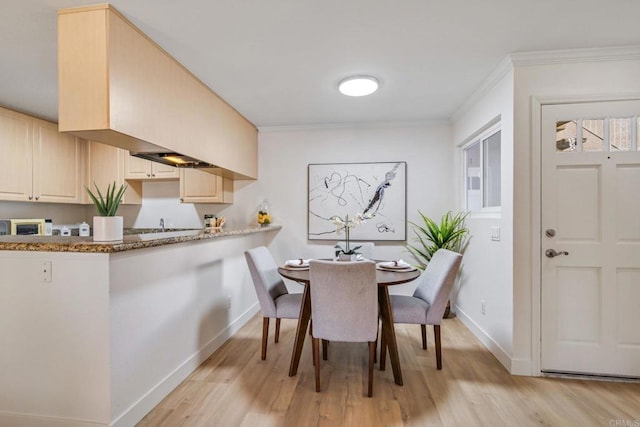 dining area featuring ornamental molding and light wood-type flooring