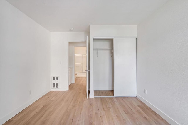 unfurnished bedroom featuring light hardwood / wood-style flooring and a closet