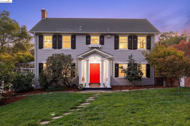 colonial inspired home with a lawn