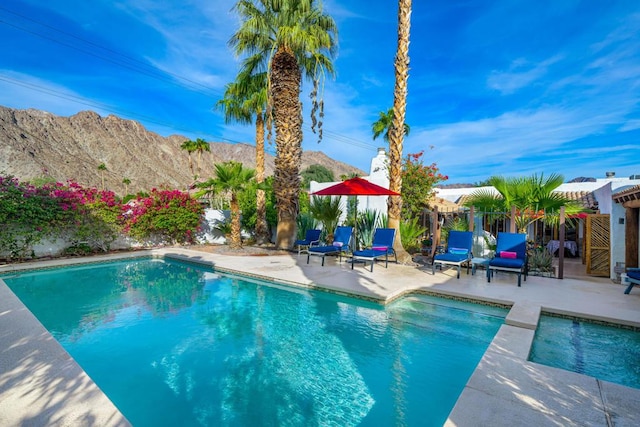 view of swimming pool featuring a mountain view and a patio