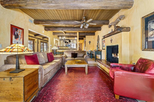 living room featuring beamed ceiling, ceiling fan, and wood ceiling