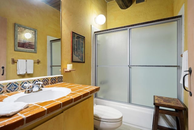 full bathroom featuring vanity, toilet, and enclosed tub / shower combo