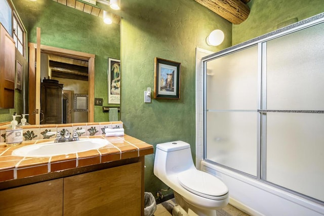 full bathroom featuring vanity, toilet, and shower / bath combination with glass door