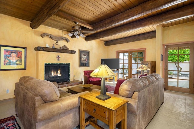 tiled living room featuring beam ceiling, a tiled fireplace, ceiling fan, and wood ceiling