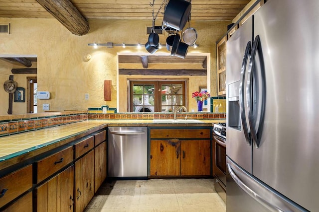 kitchen featuring wood ceiling, sink, beamed ceiling, and stainless steel appliances