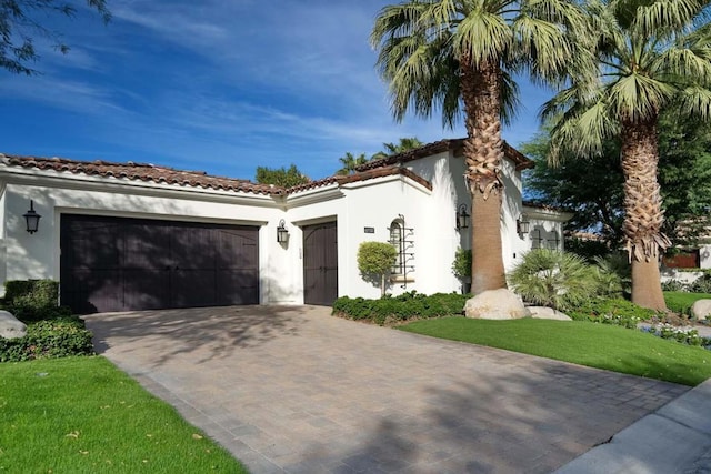 mediterranean / spanish-style home with a front yard and a garage