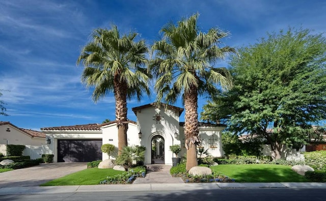 mediterranean / spanish home with a front yard and a garage