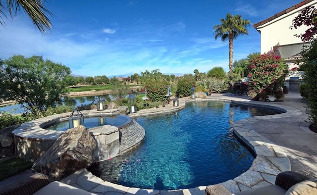 view of pool featuring a water view, a patio, and an in ground hot tub