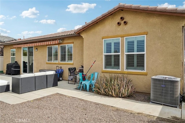 rear view of house featuring outdoor lounge area, a patio, and cooling unit