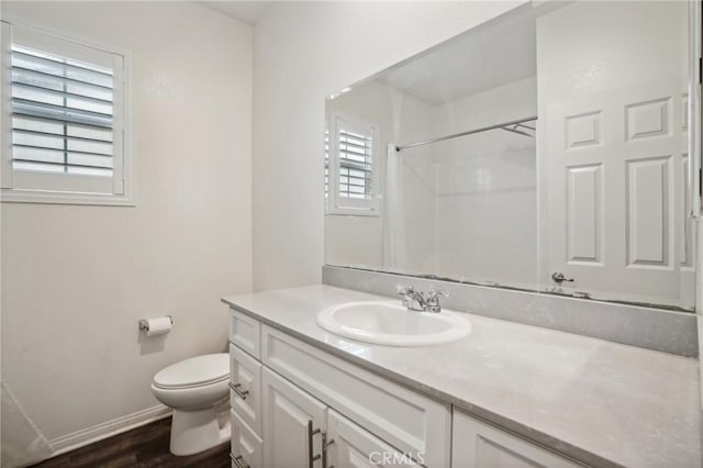 bathroom with a shower, hardwood / wood-style floors, vanity, and toilet