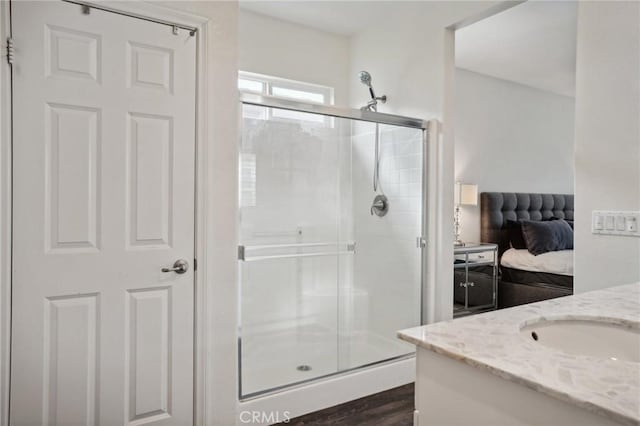 bathroom with vanity, wood-type flooring, and an enclosed shower