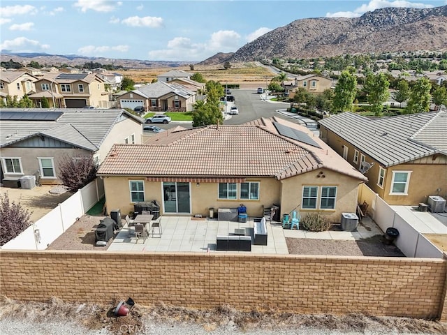 rear view of house with a mountain view, an outdoor hangout area, a patio, and central air condition unit