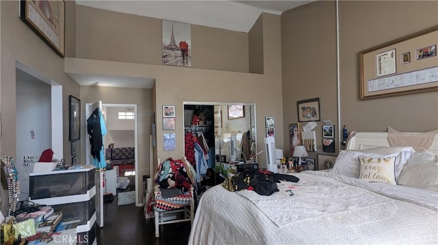 bedroom featuring a closet, a towering ceiling, and wood-type flooring