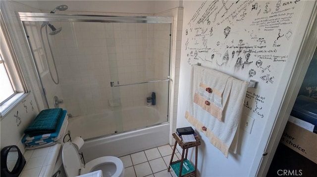 bathroom featuring tile patterned flooring, toilet, and bath / shower combo with glass door