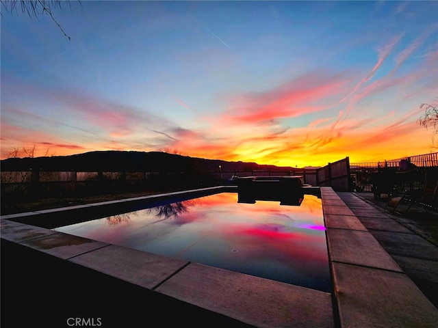 view of pool at dusk