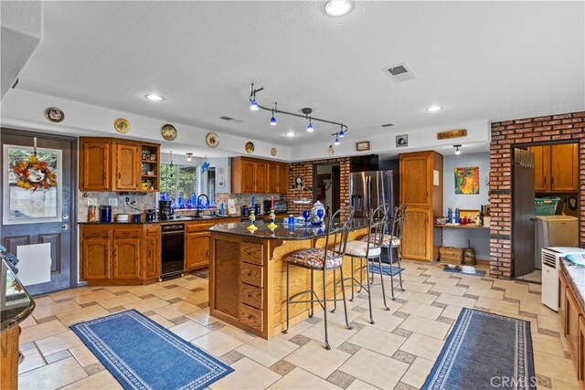 24601 Deertrail Dr, Tehachapi, CA 93561 - kitchen featuring brown cabinets, a breakfast bar, open shelves, and dark countertops