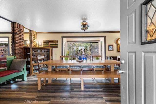 dining space featuring hardwood / wood-style floors, crown molding, and a wealth of natural light