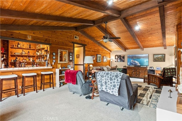 living room featuring ceiling fan, wooden ceiling, vaulted ceiling with beams, wood walls, and light colored carpet